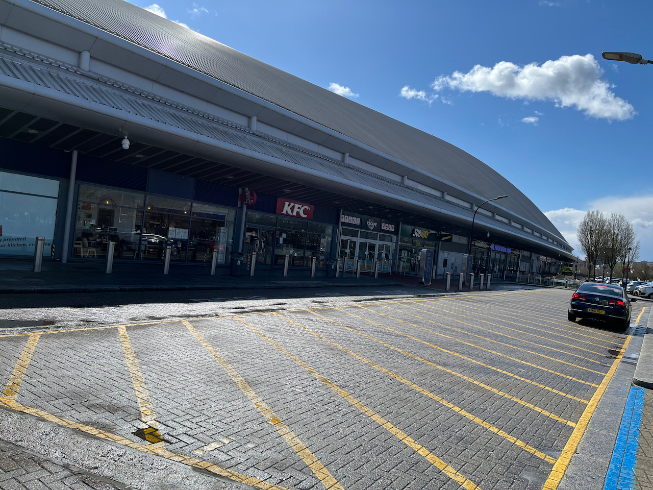 The front of Xscape, with the main entrance to the building, alongside entrances to KFC, Subway and the pub The Moon Under Water.