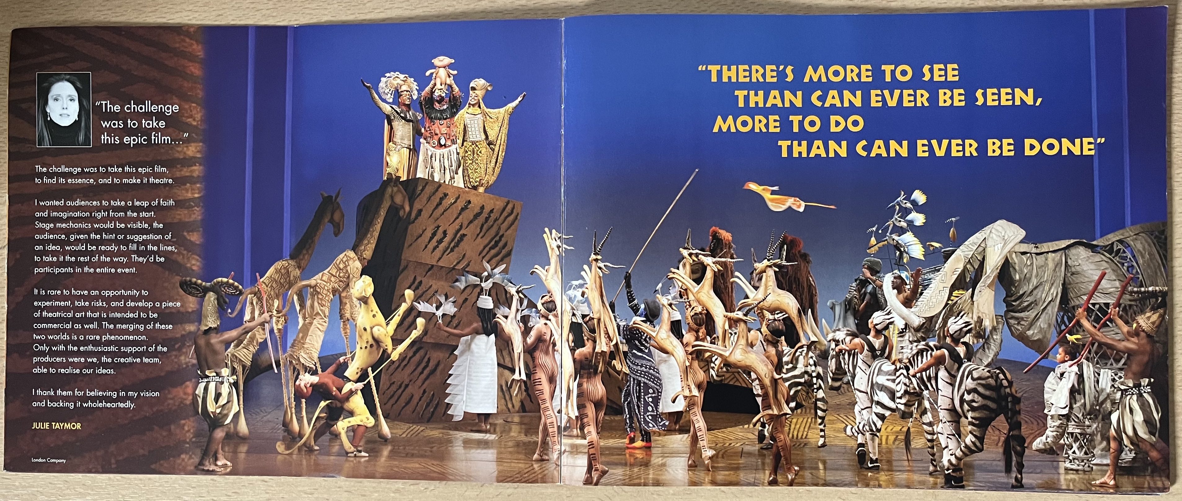 2-page spread from the programme for The Lion King, showing a large cast of actors holding up their animal puppets and facing a tall stone plinth, on top of which a man holds a baby lion aloft. Text on the right page reads There more to see than can ever be seen, more to do than can ever be done.