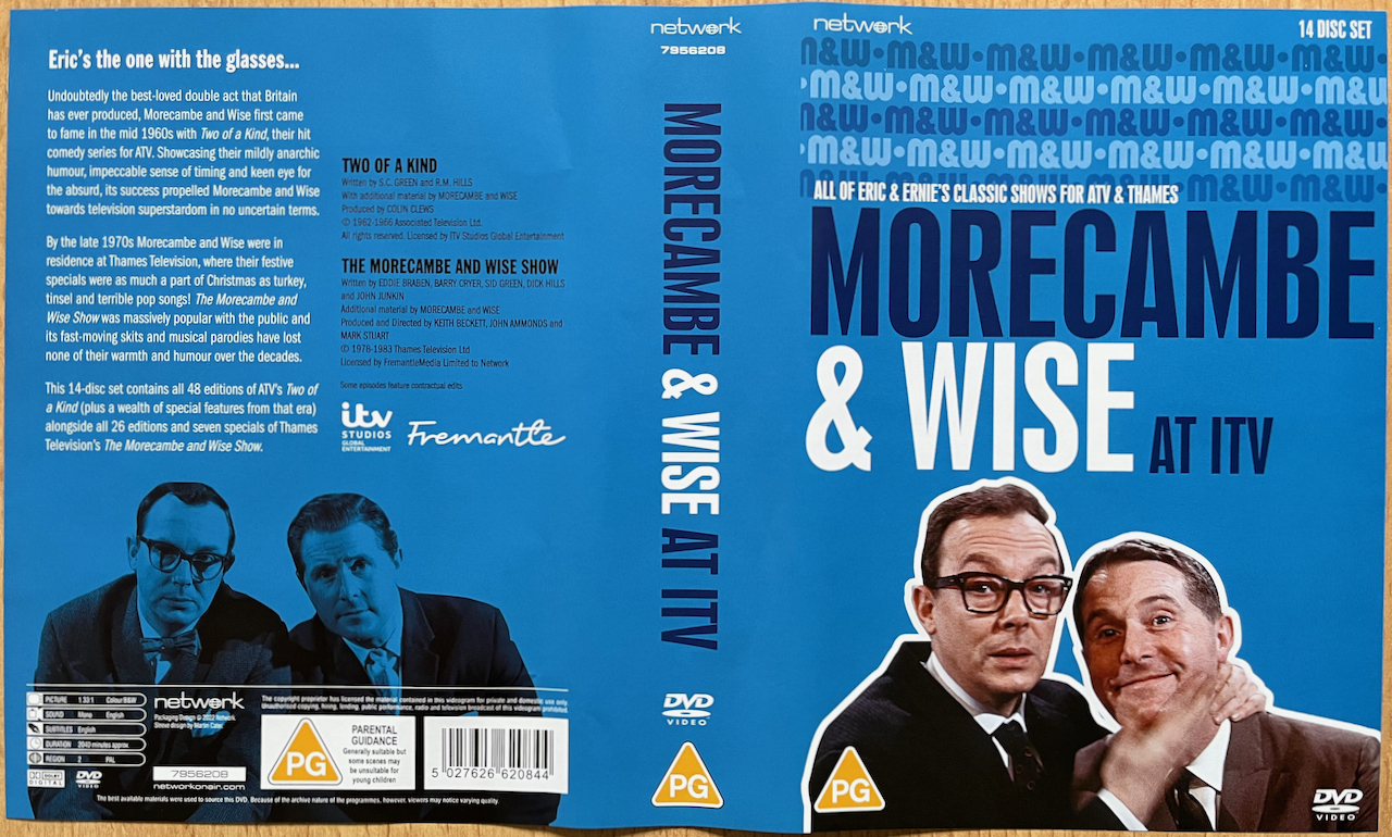Outer cover spread for the Morecambe & Wise At ITV DVD set. The cover is blue, with a colour image of the duo on the front below the title of the set. Another image of the duo appears on the back cover, below the text about the contents of set, but tinted blue this time.
