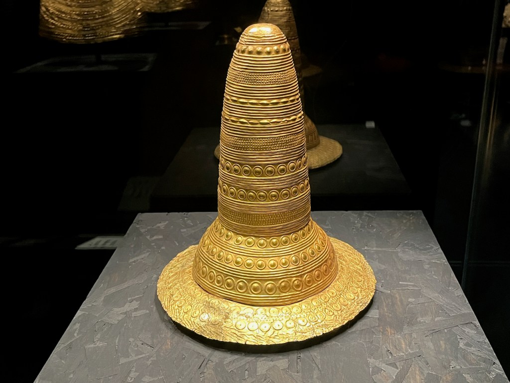 A large, ornately decorated, gold hat, with a very tall peak.
