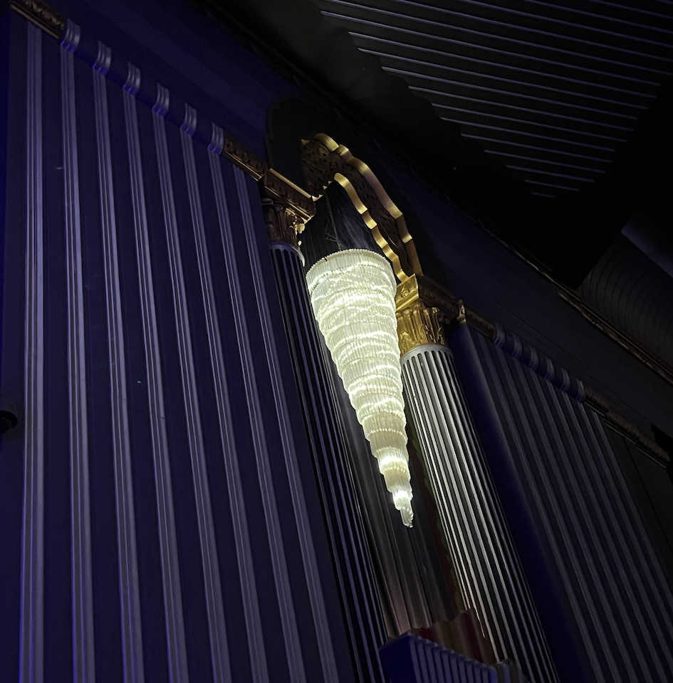 A cone shaped light hanging down from the ceiling in the Hammersmith Apollo auditorium.