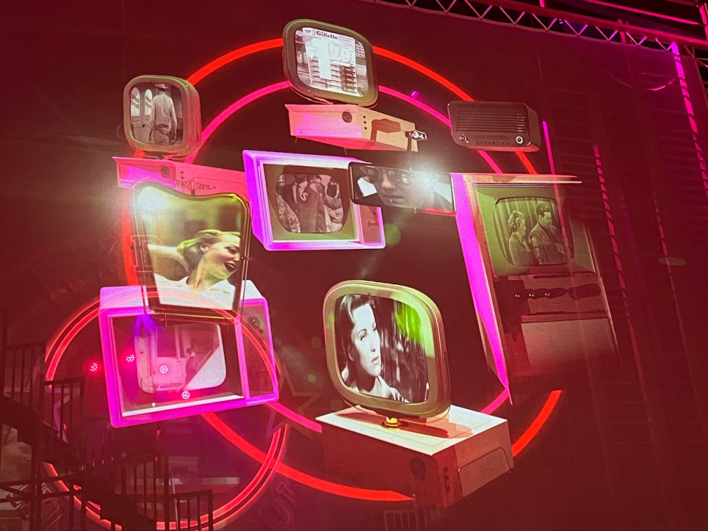 A collage of screens shown on the Dominion Theatre stage, playing clips from TV shows, films and adverts in 1950s America.