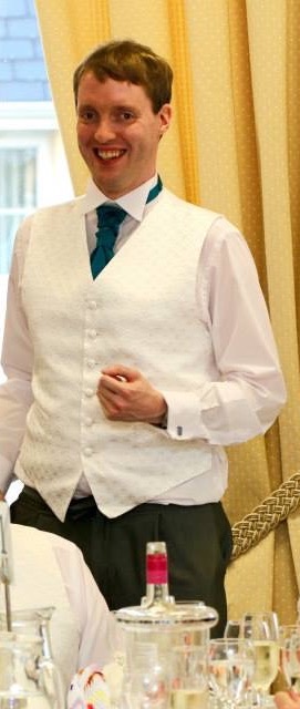 Glen smiling in his white shirt and ruffled green tie as he delivers his best man speech.