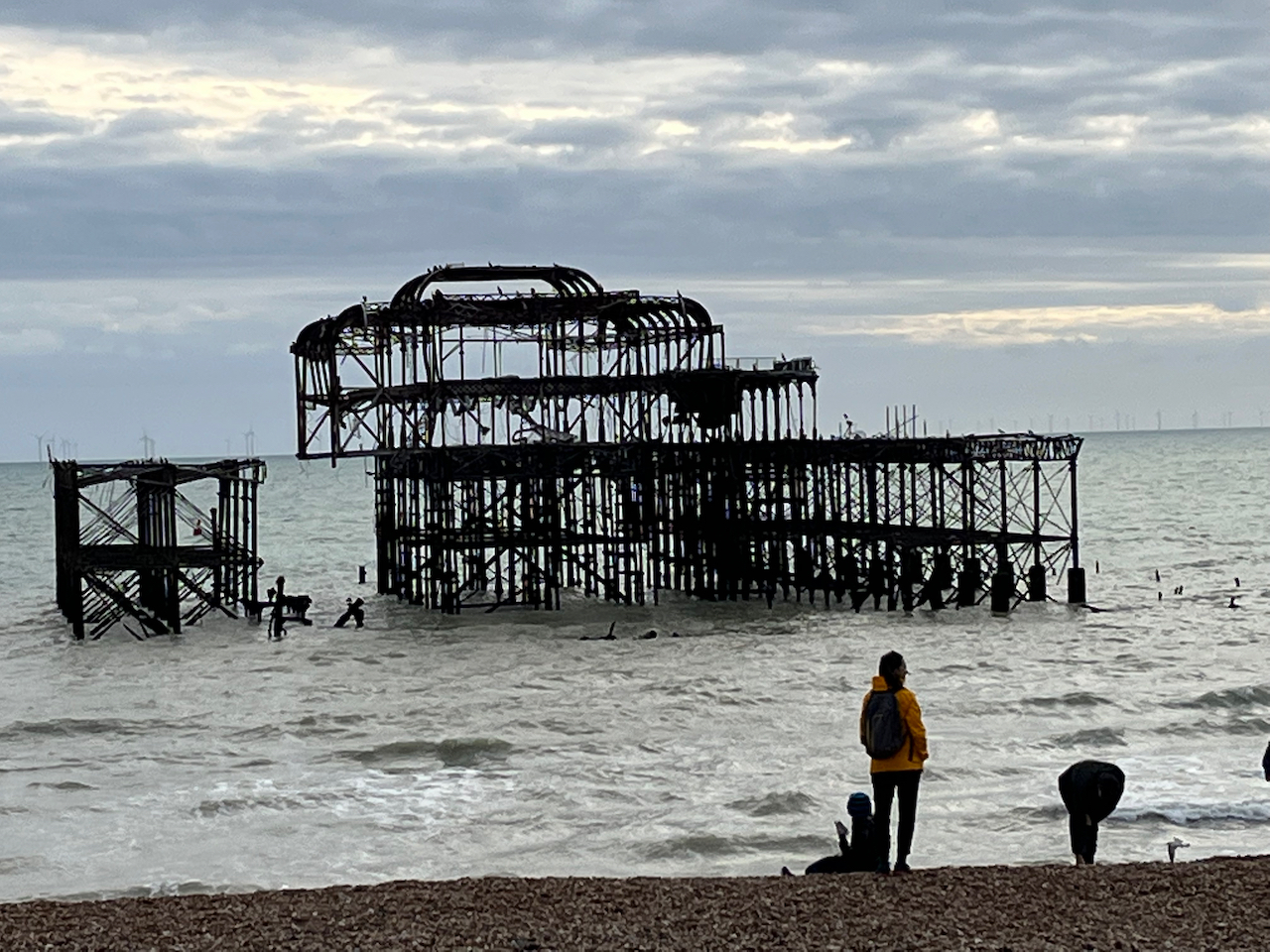 The black burnt out frame of the ruined Brighton West Pier, a short distance out at sea.