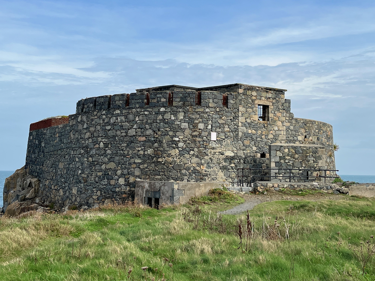 The ruins of a stone fort called Fort Doyle, in a grassy area on the coast.