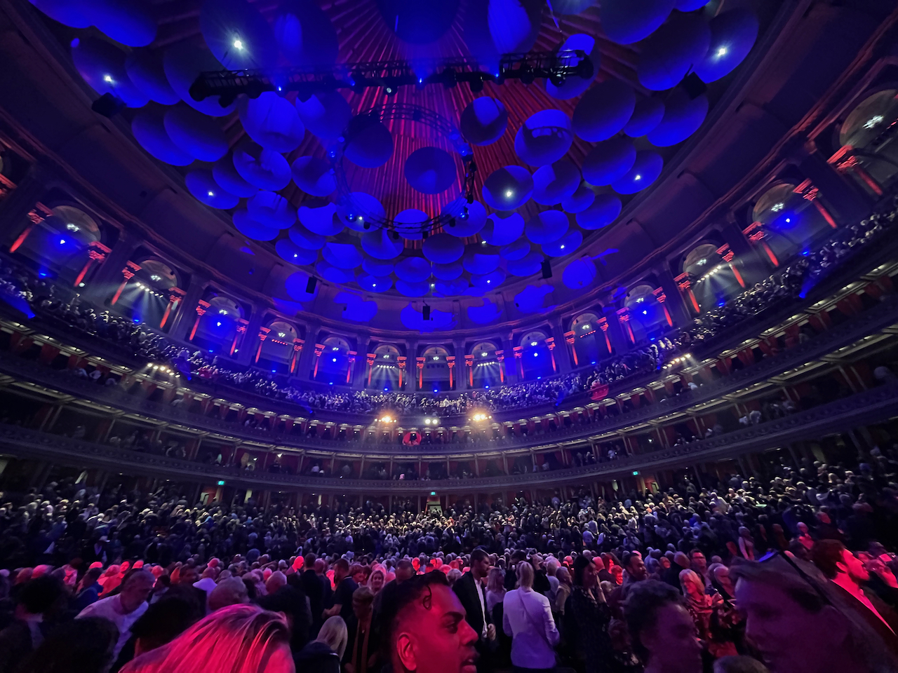 The huge circular auditorium of the Royal Albert Hall, filled with people.