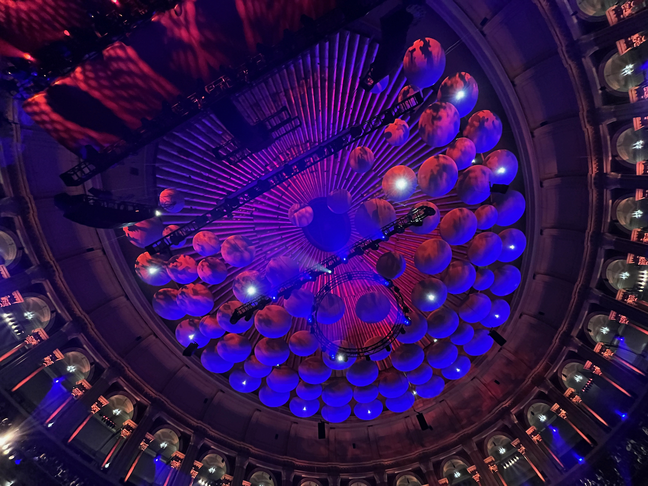 85 mushroom-shaped acoustic diffusers, lit up in blue, hanging from the ceiling of the Royal Albert Hall auditorium. These eliminate echo to ensure the best possible sound quality.