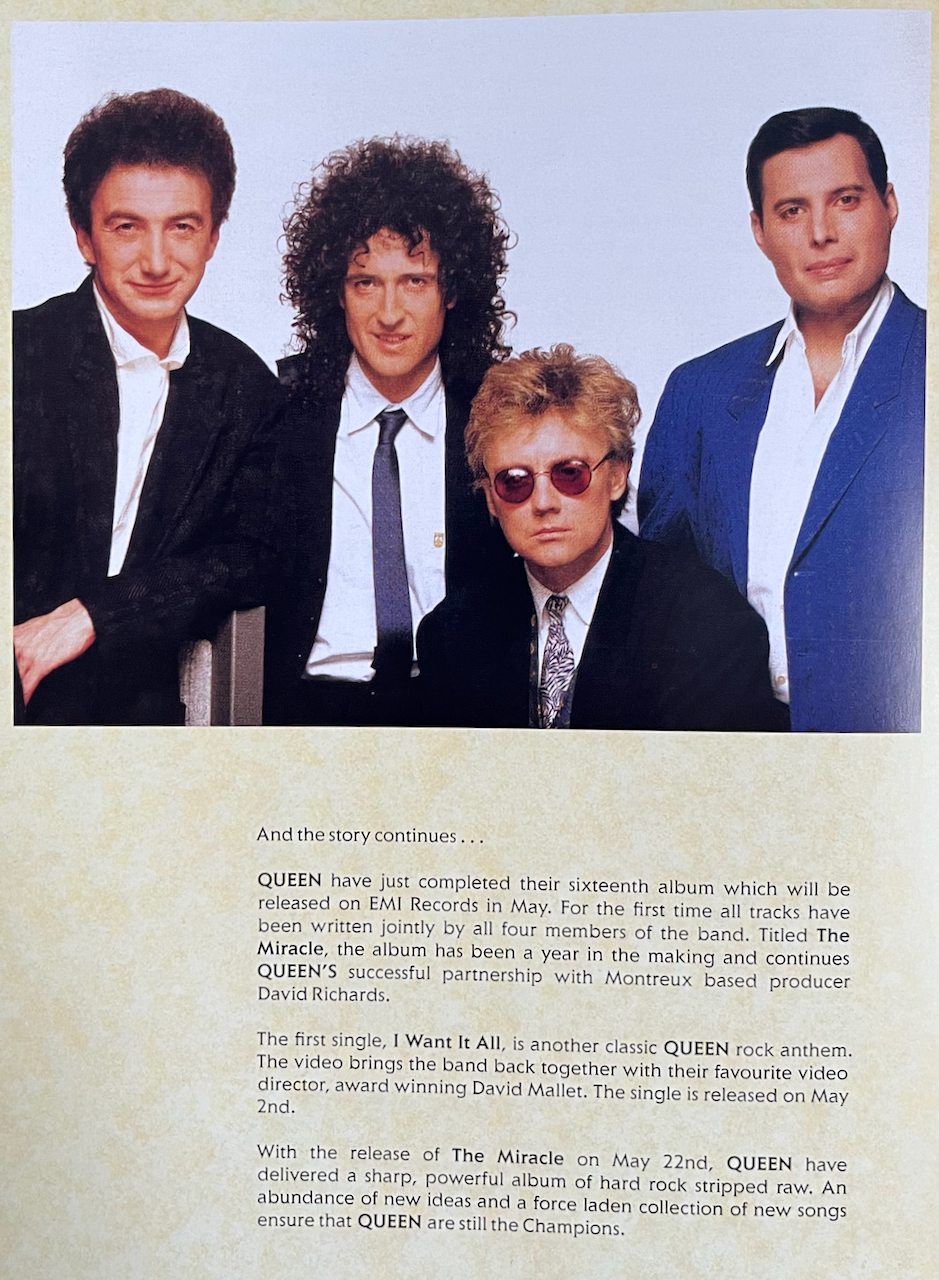 A photo of Queen posing together, above some text about the release of their new album The Miracle. From left to right, John, Brian and Roger are wearing black jackets with white shirts, while Freddie is wearing a blue jacket over his white shirt. Brian is wearing a plain navy-coloured tie, while Roger is wearing sunglasses and a patterned tie.