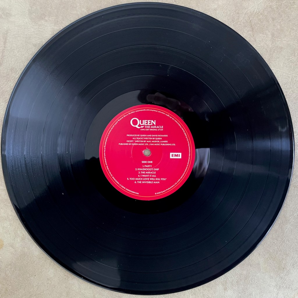 The vinyl LP from Queen's box set for The Miracle, with a red label in the centre containing the name of the tracks on that side of the record.