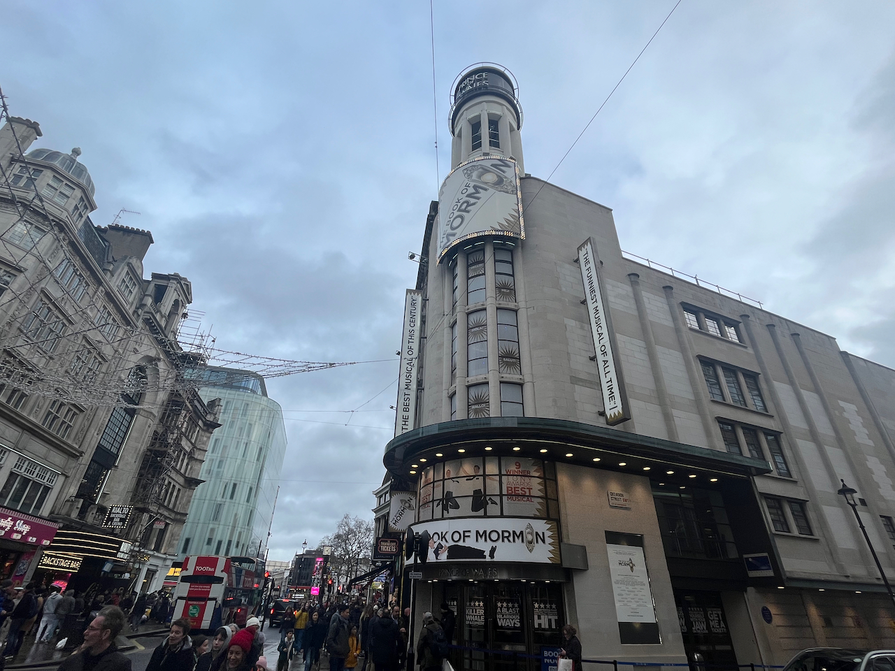 The Prince Of Wales Theatre, with posters and signs for The Book Of Mormon.