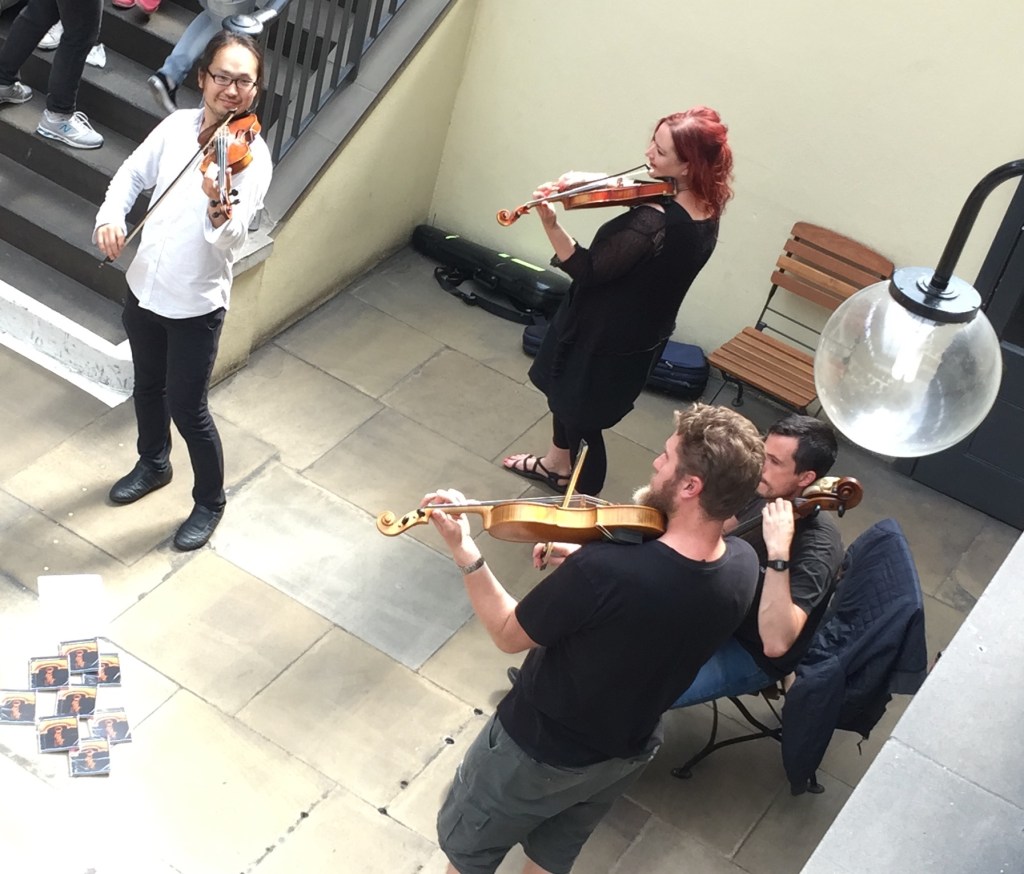 A quartet of violinists playing in the dining area in Covent Garden.