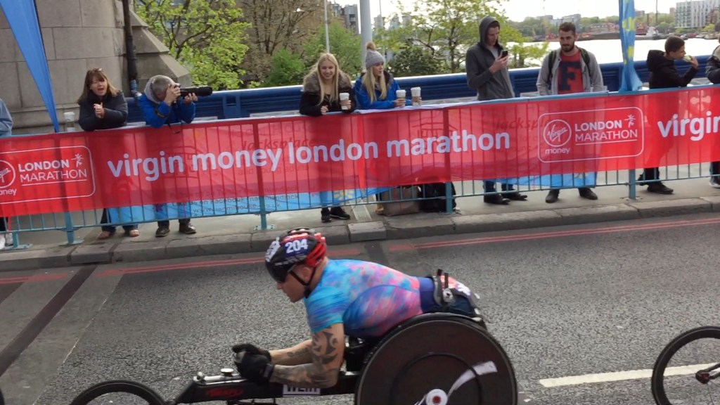Paralympic wheelchair athlete zooming past on Tower Bridge.