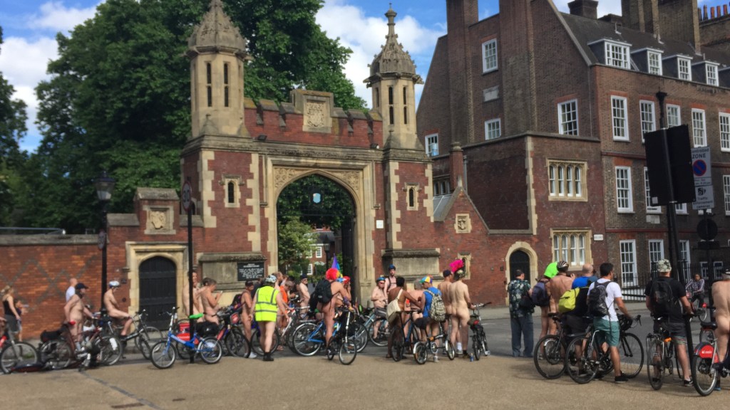 A large crowd of cyclists, most of them without clothes on, outside the historic Lincoln's Inn building.