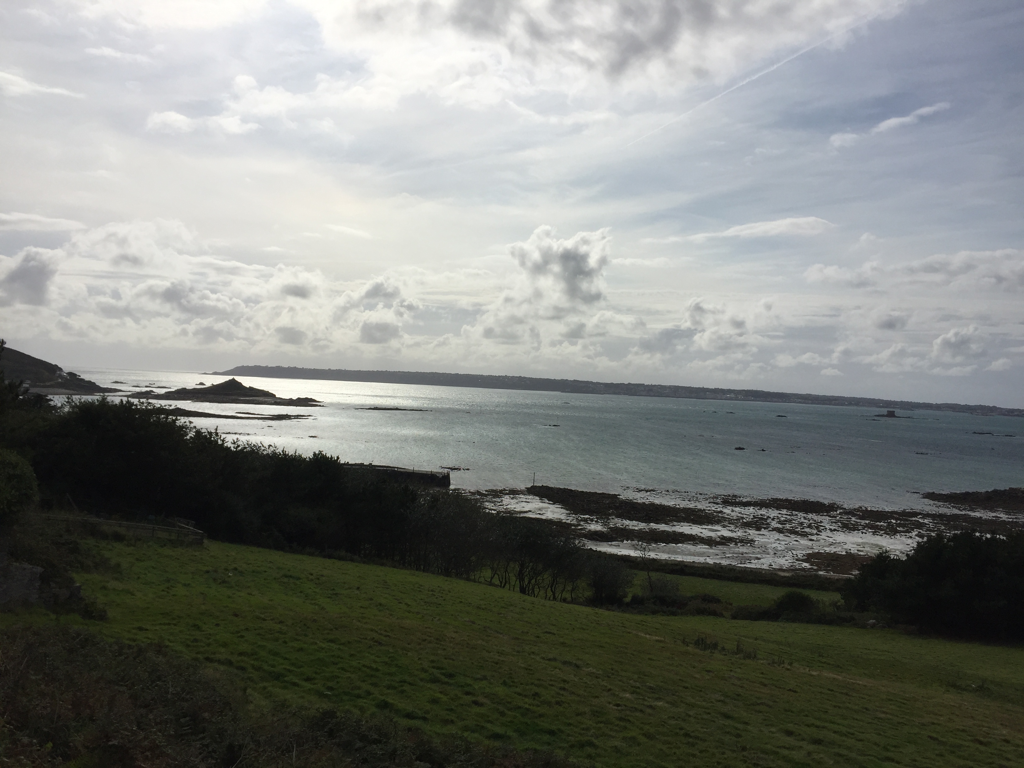 View from up on a hill on Herm Island, across the water to the island of Guernsey on the horizon.