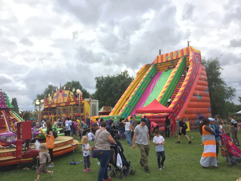 A very tall, wide, colourful, inflatable bouncy castle style slide, called Big Top, with steps either side of the central slide for children to climb up.