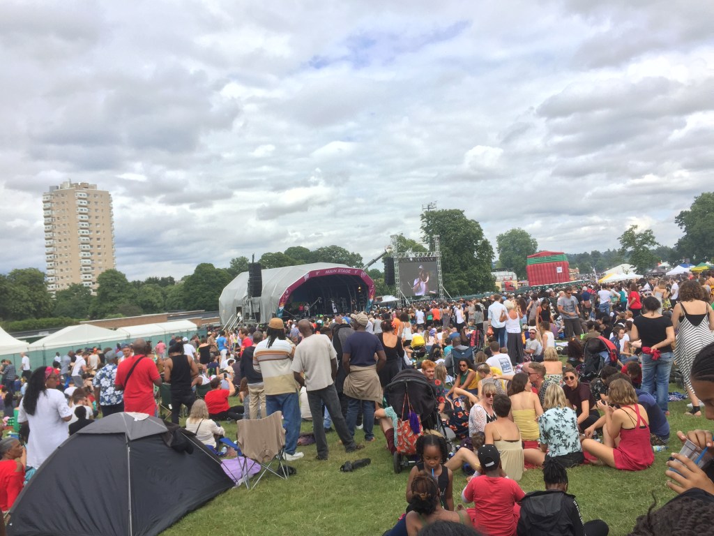 A large crowd of people on the grass in front of the main stage at the Lambeth Country Show.