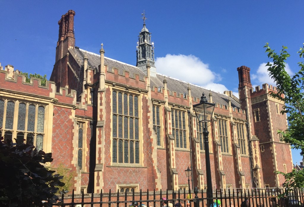 The right side of the large brick Lincoln's Inn building, which looks a bit like a church. It has big windows along the structure, and criss-crossing grey diagonal lines forming diamond shapes on the brickwork.