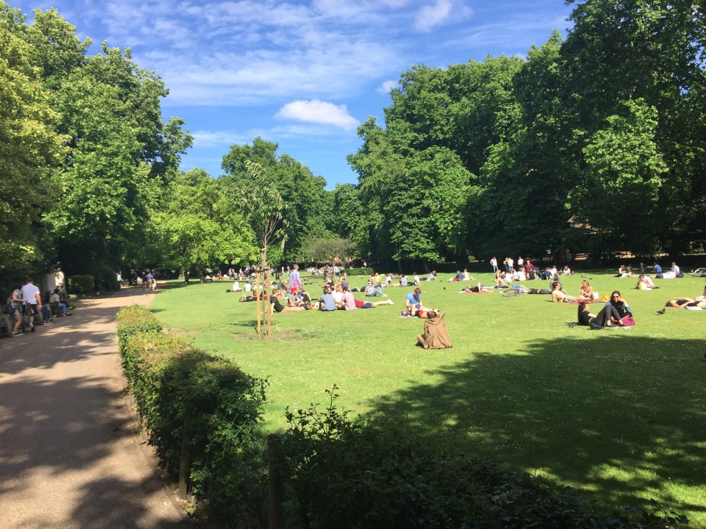 People relaxing in the sunshine on the grass in Lincoln's Inn Fields.