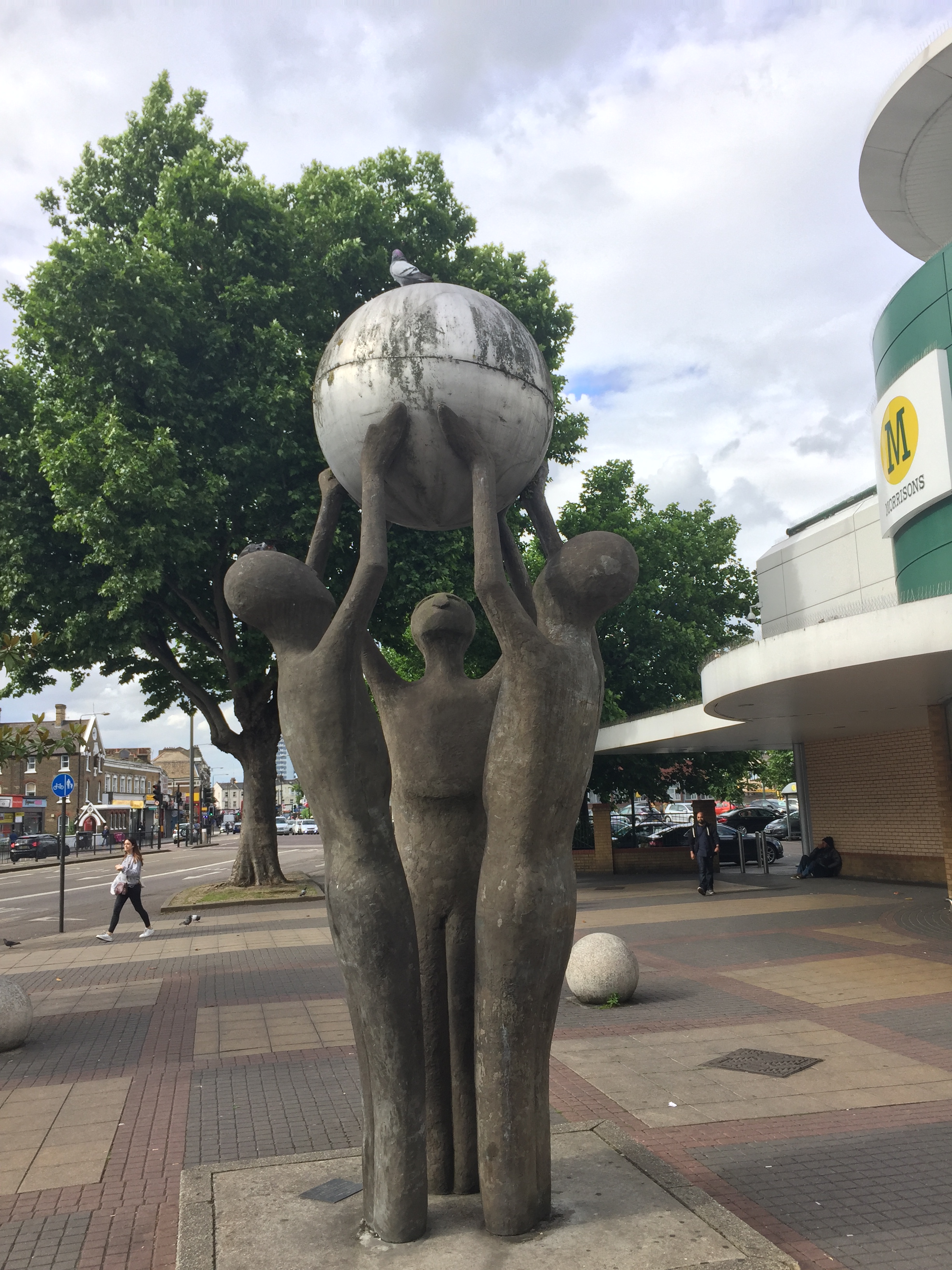 The Peace Sculpture by Derrick Richardson-Lee, showing 3 figures holding a globe together above their heads.