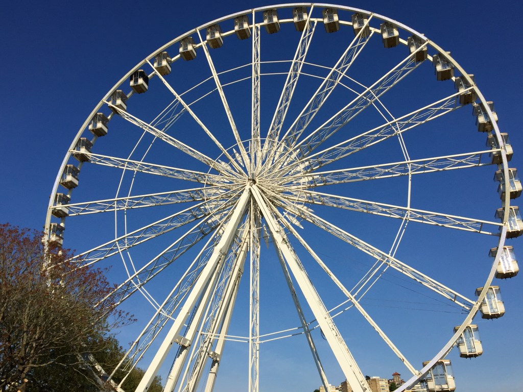 Close-up of the Riviera Wheel, which is a big white ferris wheel in Torquay, beneath a clear blue sky.
