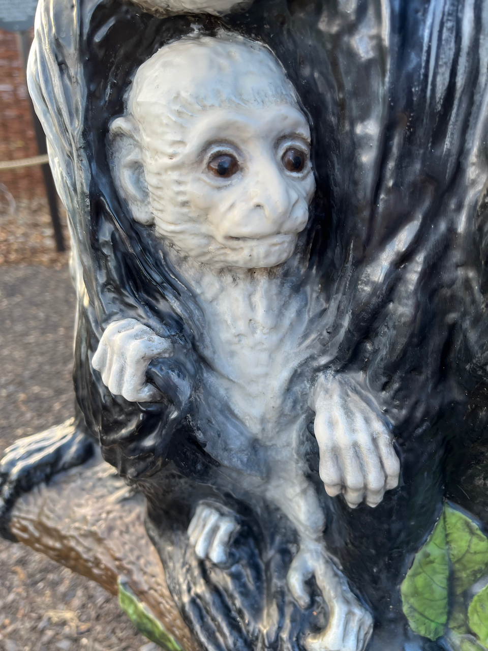 Close-up of a statue of a white baby colobus monkey.