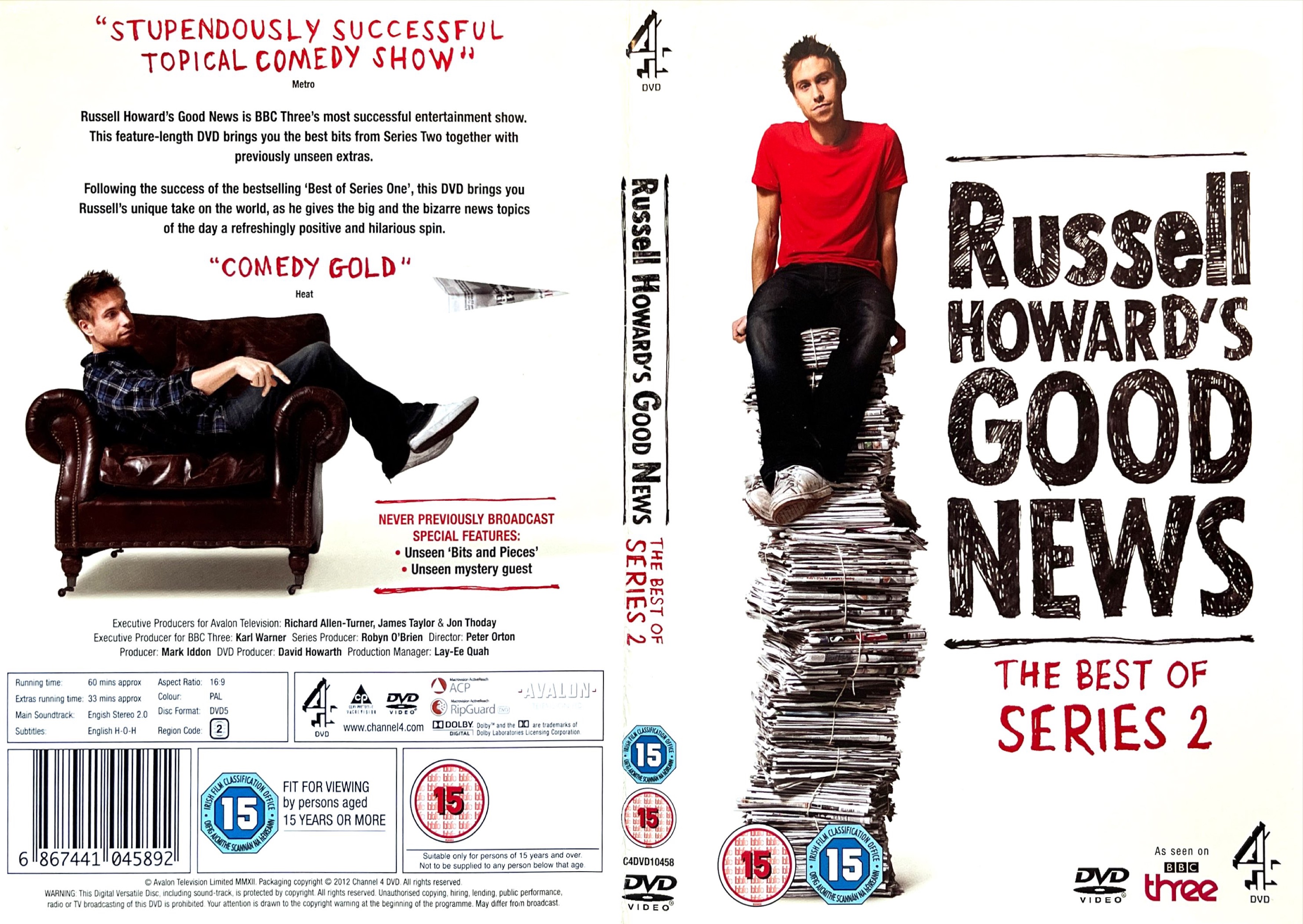 DVD cover spread for Russell Howard's Good News - The Best Of Series 2. The front cover shows Russell, in a red t-shirt, black trousers and white trainers, sitting on top of a very tall pile of newspapers. The back cover shows him lazing on a leather chair, positioned sideways so that his back rests against one arm of the chair while his legs rest over the other arm in front of him.