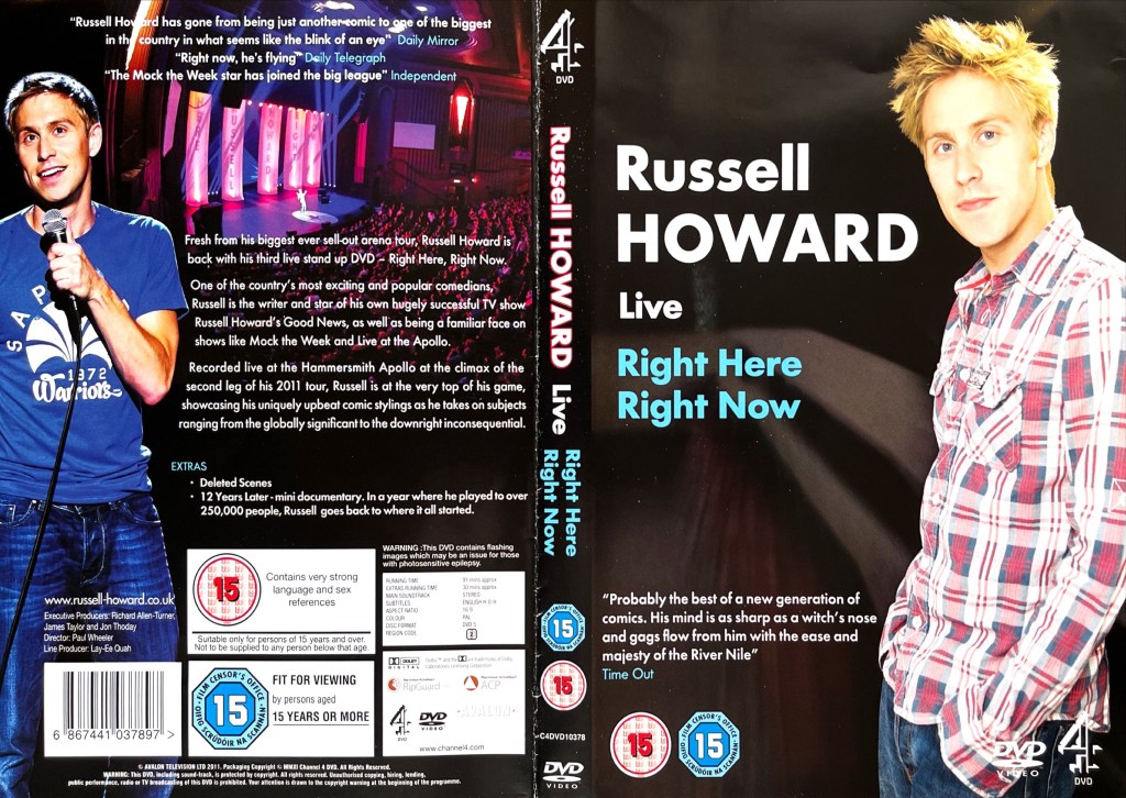 DVD cover spread for Russell Howard - Right Here, Right Now. The front cover shows Russell standing in a red checked shirt, against a background that makes it look like he's casting a shadow in the doorway of a dark room. The back cover shows images of Russell performing in the show alongside the description of the DVD.