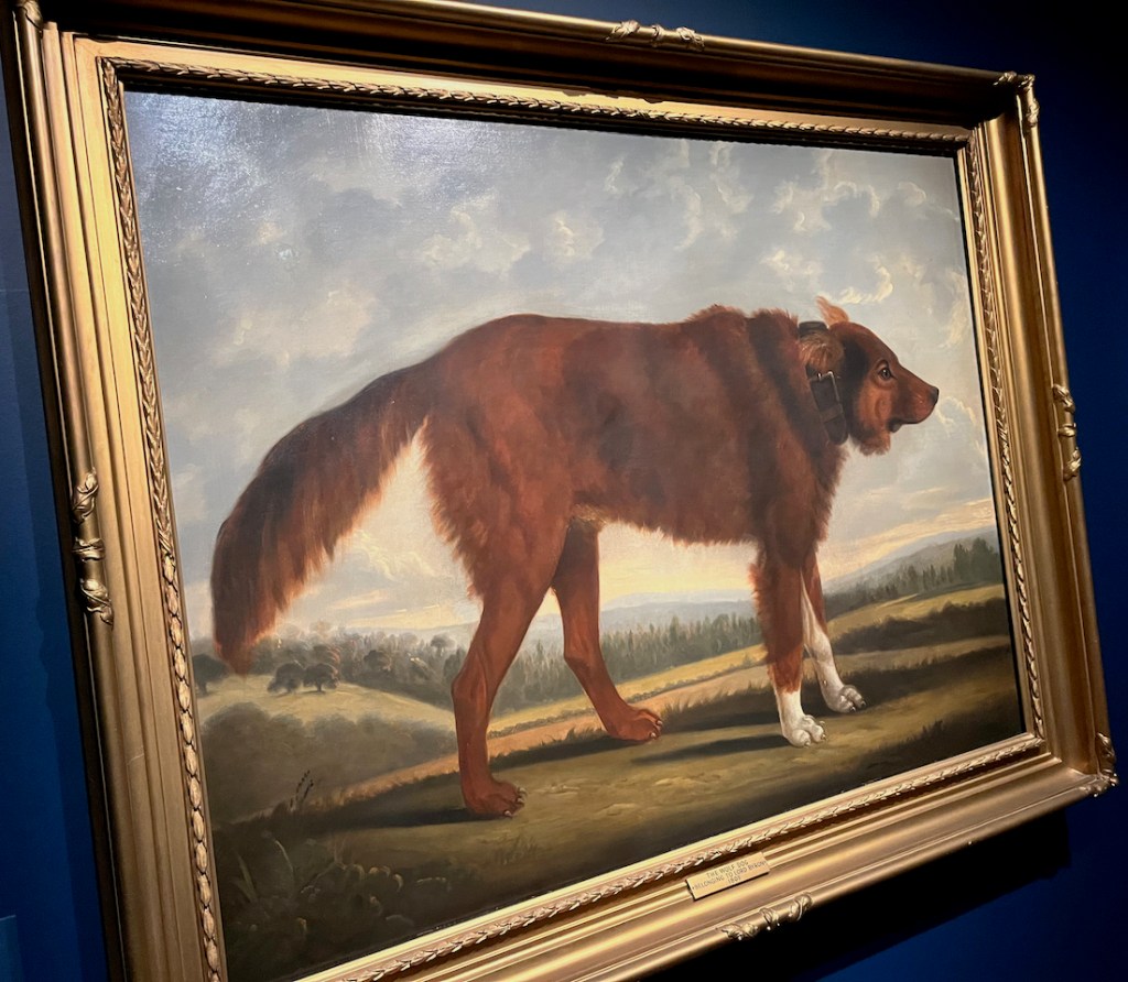 A painting of a large brown dog standing in a field, with trees and hills in the background.