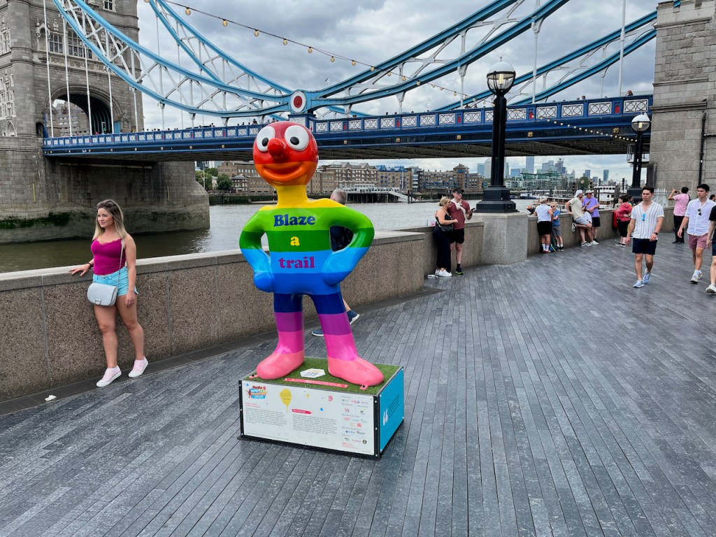 Blaze A Trail, a statue of Morph decorated in thick rainbow coloured stripes from head to toe.