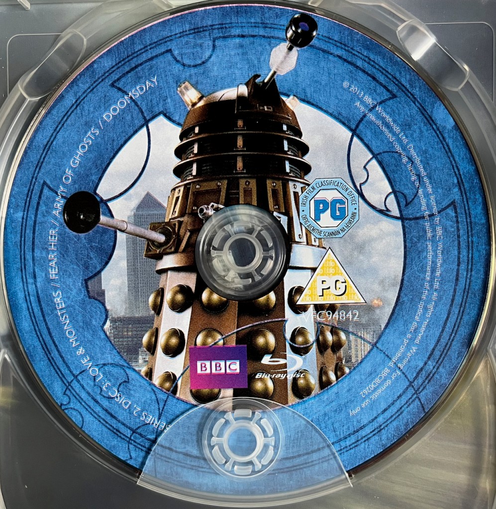 Disc 3 in the Doctor Who Series 2 Blu-ray set, featuring a photo of a Dalek. A blue border around the edge of the disc contains the episode names and copyright information.