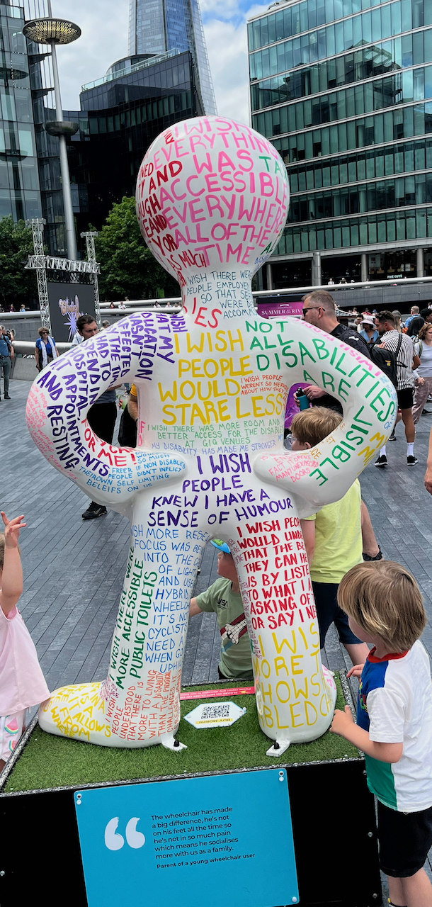 The back of the Messenger Morph statue, with lots of coloured writing all over it. For example, I wish everything was accessible everywhere all of the time, I wish people would stare less, I wish people knew I have a sense of humour, I wish there were more accessible public toilets, I wish there was more room and better access for the disabled at gig venues, and my disability has made me stronger.