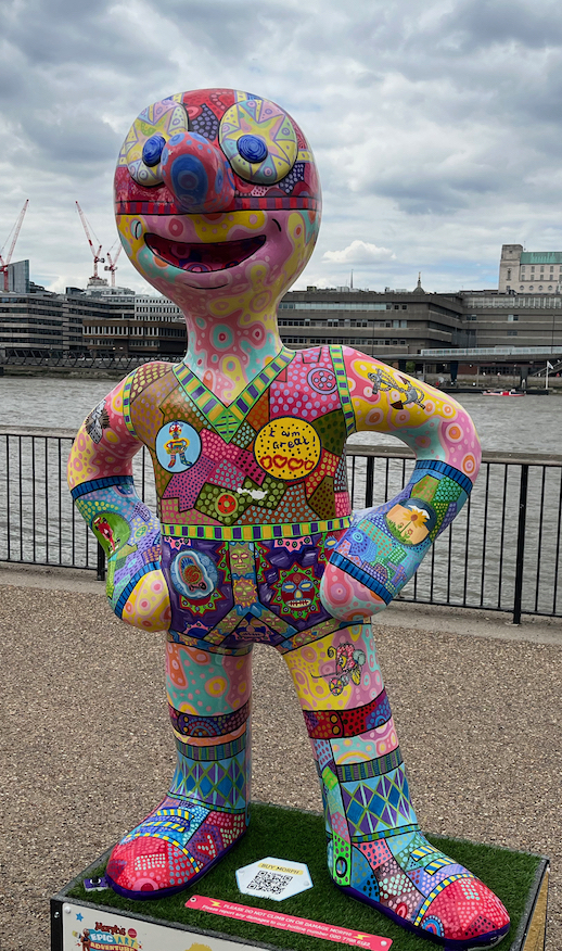 Morph Whizz Kidz Argonaut, a statue of Morph covered in a bright array of colourful patterns and designs, including a yellow badge saying I Am Great, some faces, lots of colourful dots and stripes, and other random imagery.