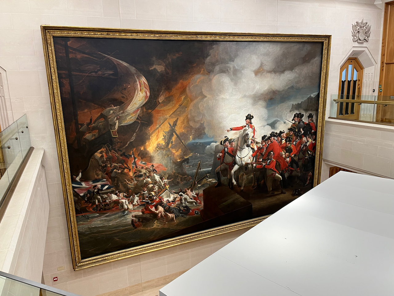 A painting by John Singleton Copley called Defeat of the Floating Batteries at Gibraltar. It shows the British Governor of Gibraltar on horseback, with his army behind him, pointing towards the defeated Spanish sailors and their boats that have gone up in flames. The painting is so huge that it spans two floors in the Guildhall Art Gallery.