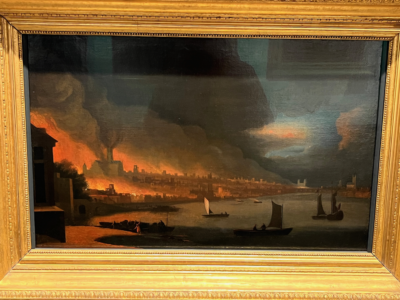 A painting of the Great Fire Of London by Waggoner, showing flames and smoke billowing into the air from buildings along the bank of the Thames.