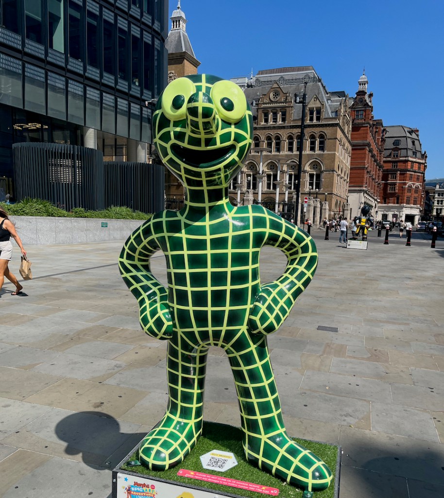 Morph Target, a statue of Morph covered in a grid of light green lines on his dark green body.