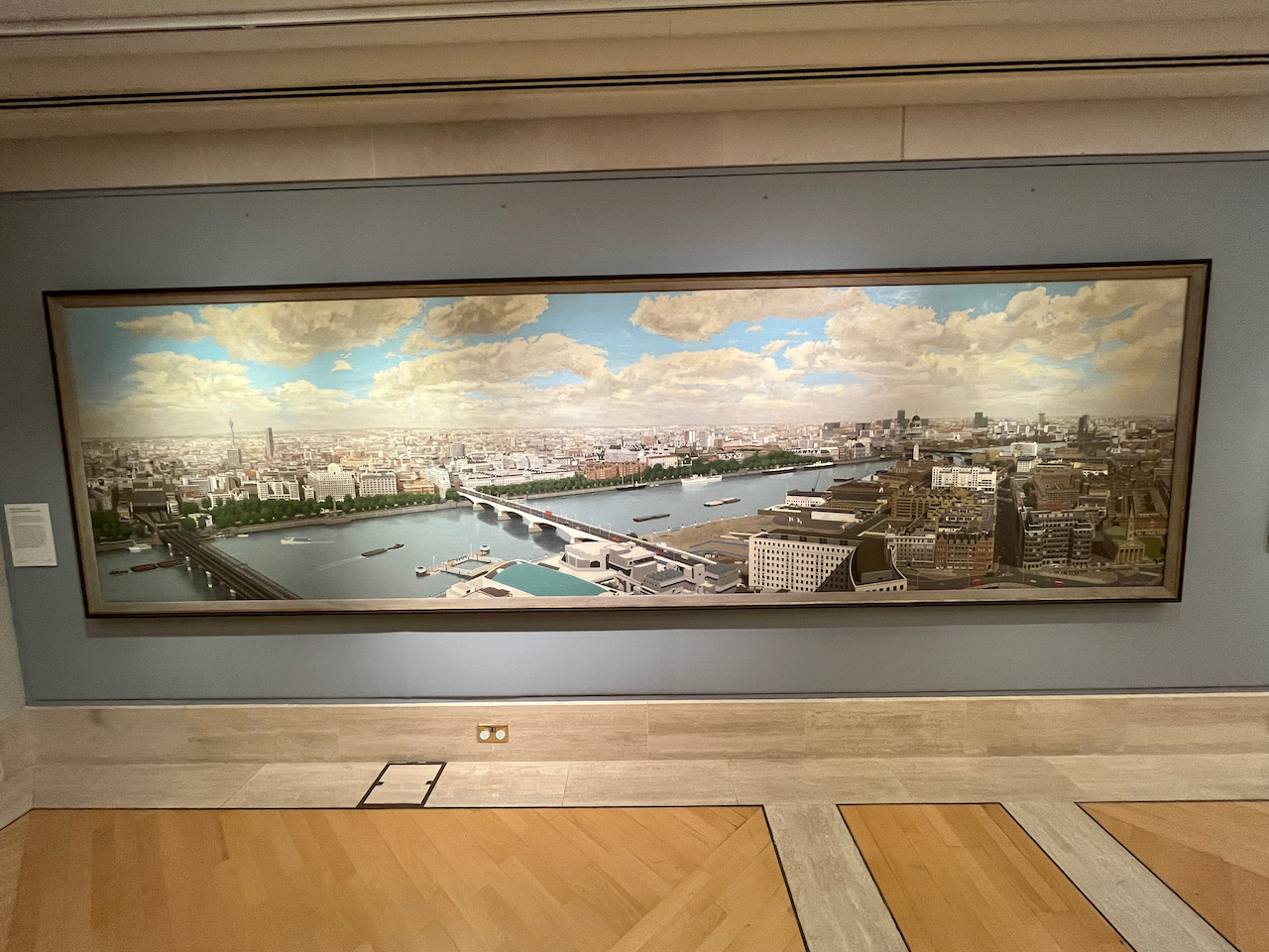 A very wide painting by David R Thomas showing a panoramic view of the River Thames, with the buildings on the north bank on the far side stretching far into the distance.