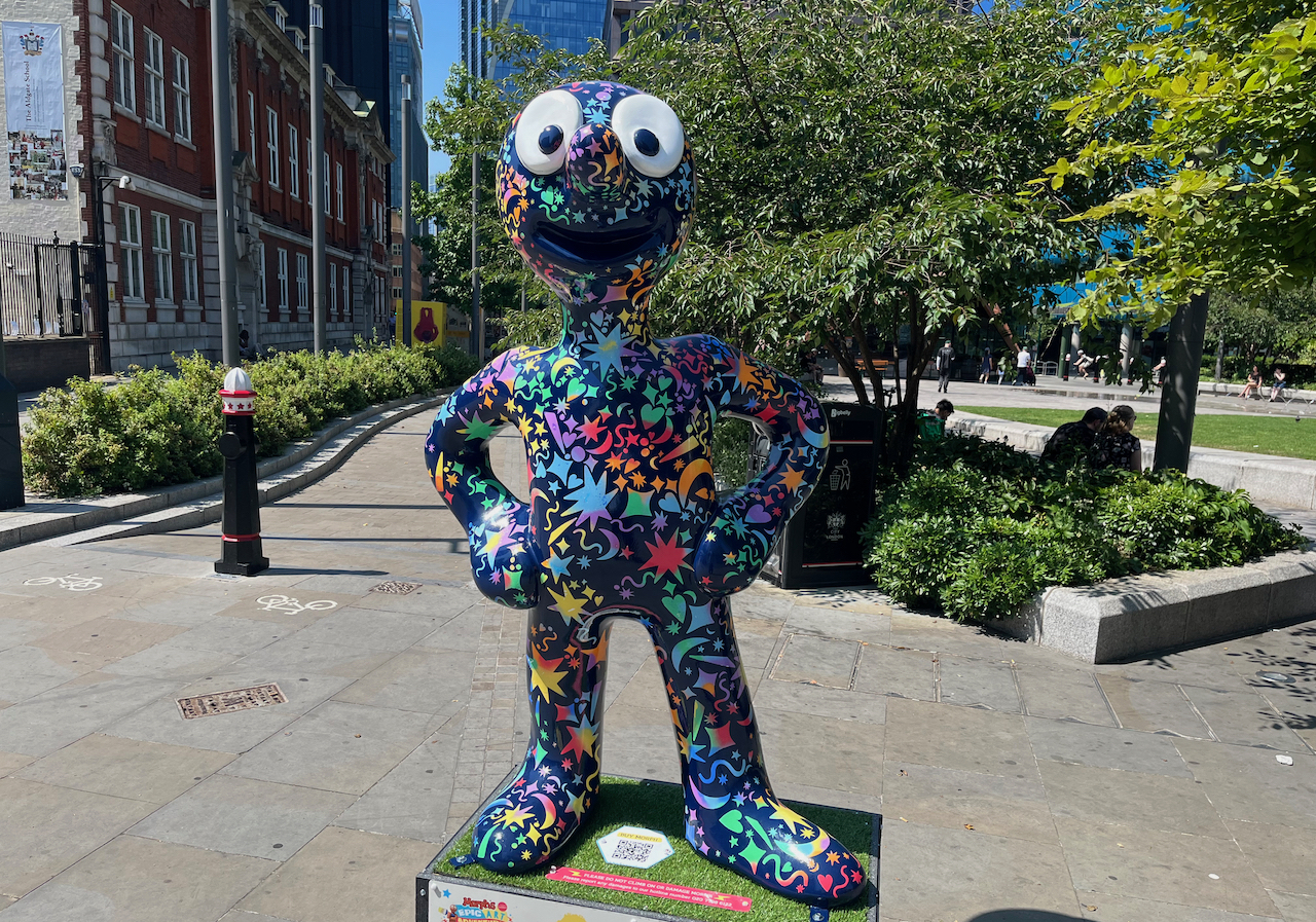 Whizz Bang, a statue of Morph whose dark navy body is covered from head to toe in hundreds of colourful explosive stars, hearts and other shapes.