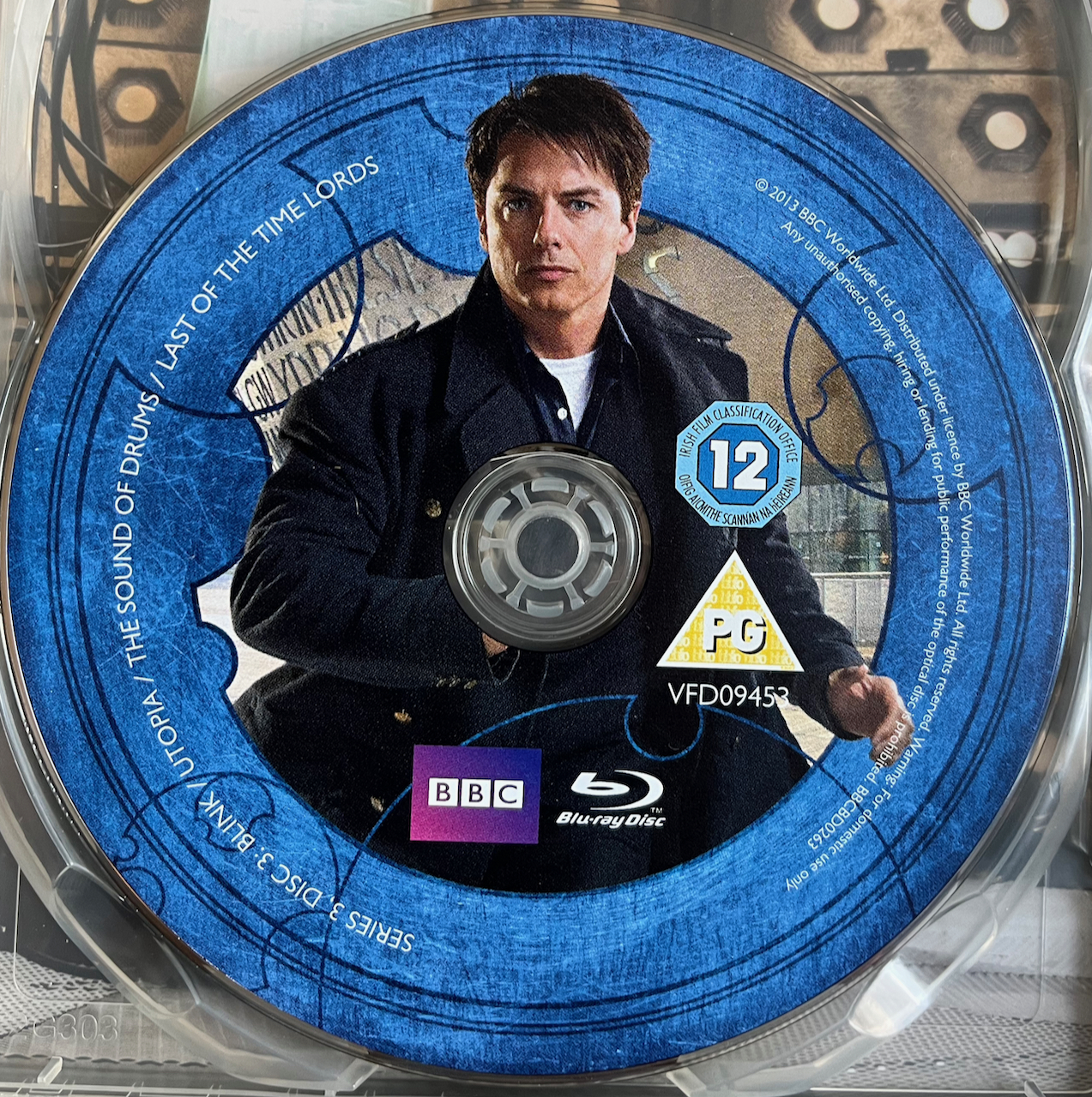 Disc 3 in the Doctor Who Series 3 Blu-ray set, featuring a photo of Captain Jack Harkness in a black jacket over a white t-shirt. A blue border around the edge of the disc contains the episode names and copyright information.