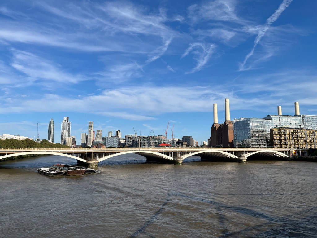 The Grosvenor Railway Bridge with wide arches along its length, going across the River Thames, with Battersea Power Station in the background.