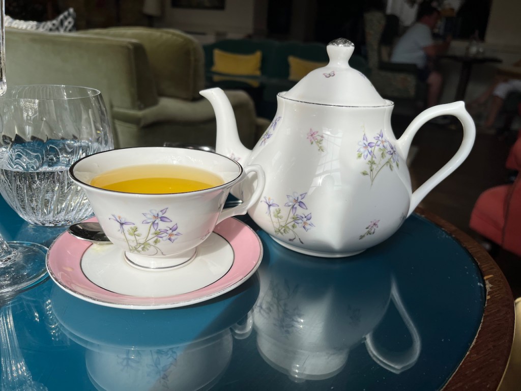 Camomile tea, with a little floral decoration on the cup and teapot.