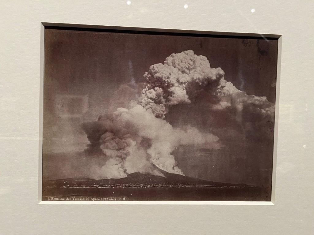 Black and white photo of Mount Vesuvius erupting, with huge plumes of smoke in the sky.