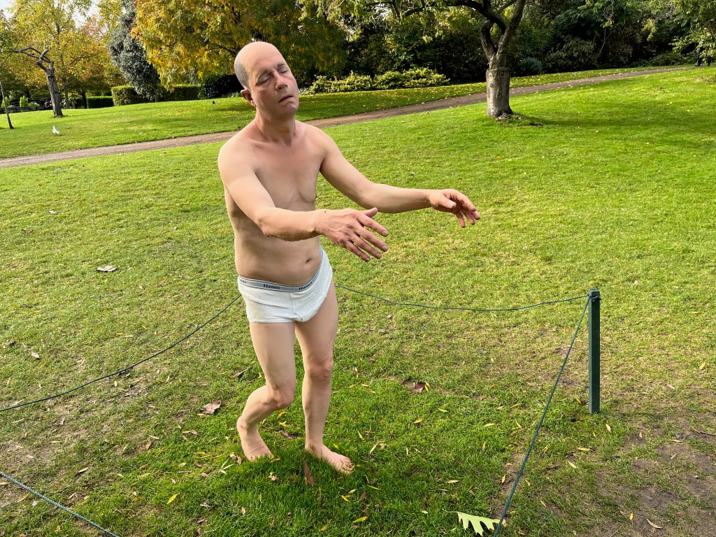 A realistic sculpture of a man sleepwalking, with his arms out in front of him, dressed only in white underpants. The artwork is called Sleepwalker by Tony Matelli.