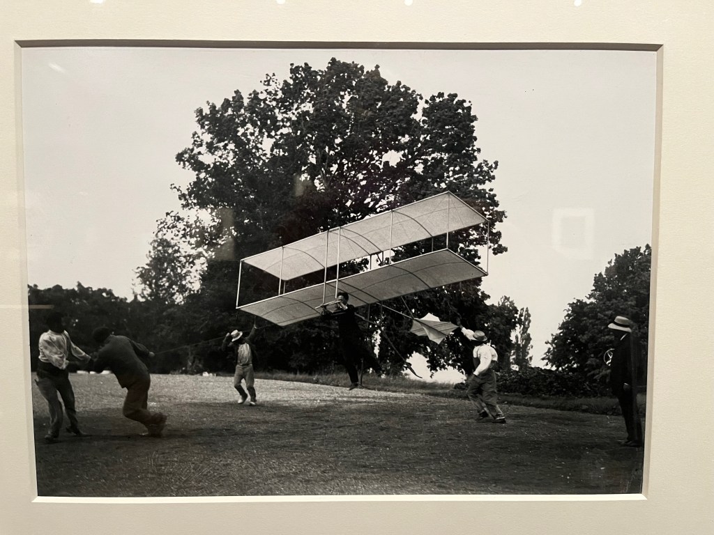 Black and white photo of a man launching a home made glider.