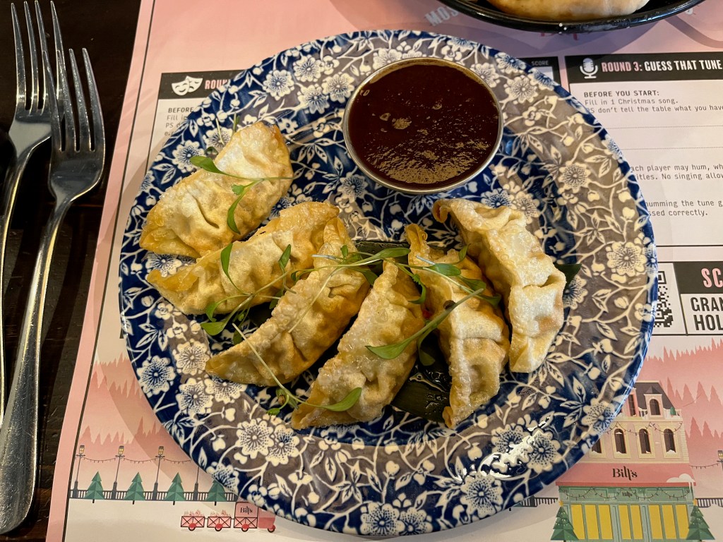 Five chicken and sesame dumplings at Bill's, with a dipping pot of spicy sauce.