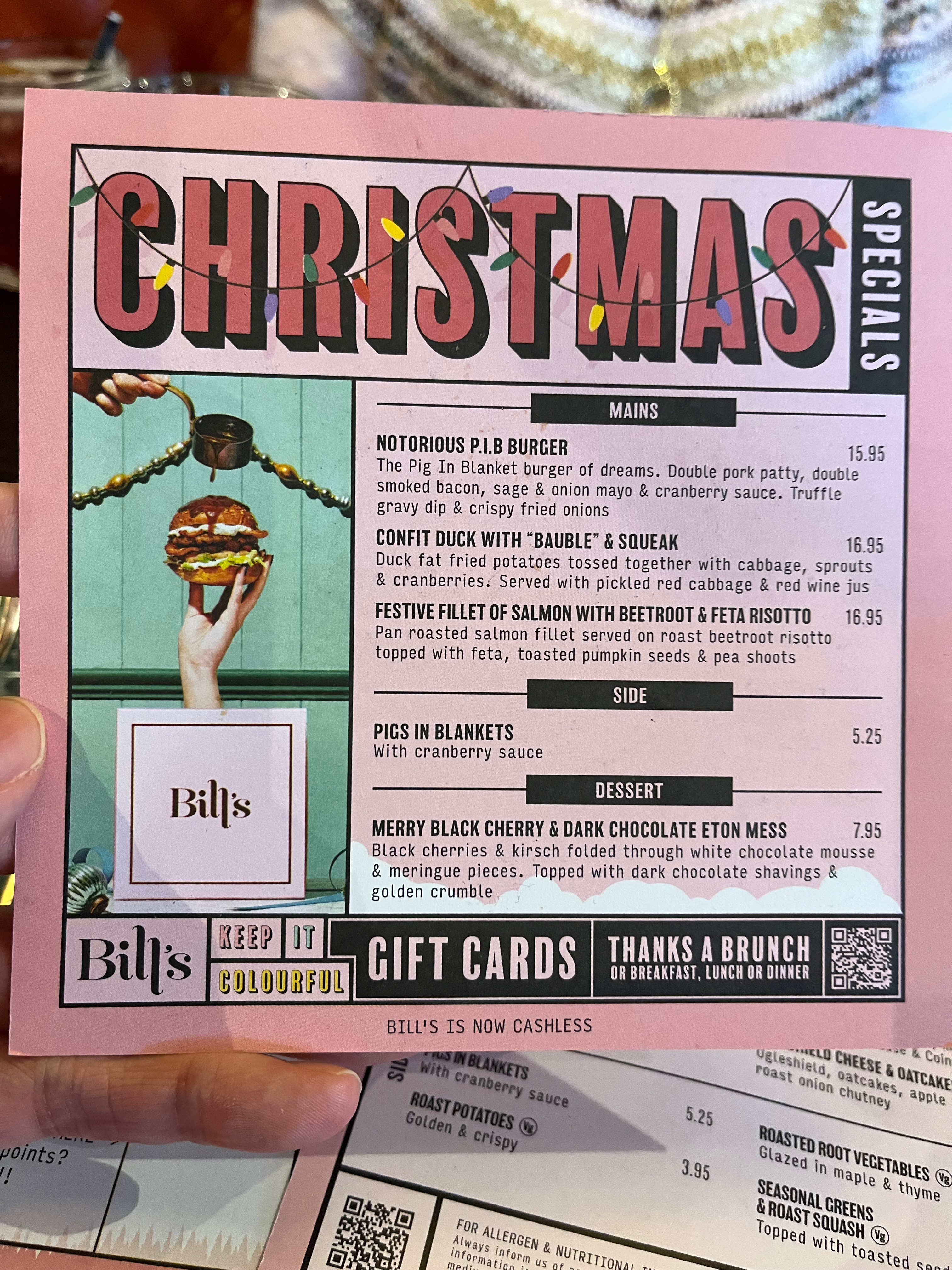 Bill's Christmas Specials Food menu. The main courses are the Notorious Pigs In Blankets Burger, Confit Duck with Bauble and Squeak, or Festive Fillet of Salmon with Beetroot and Feta Risotto. A side of Pigs In Blankets can be added. The dessert option is a Merry Berry Black Cherry and Dark Chocolate Eton Mess.