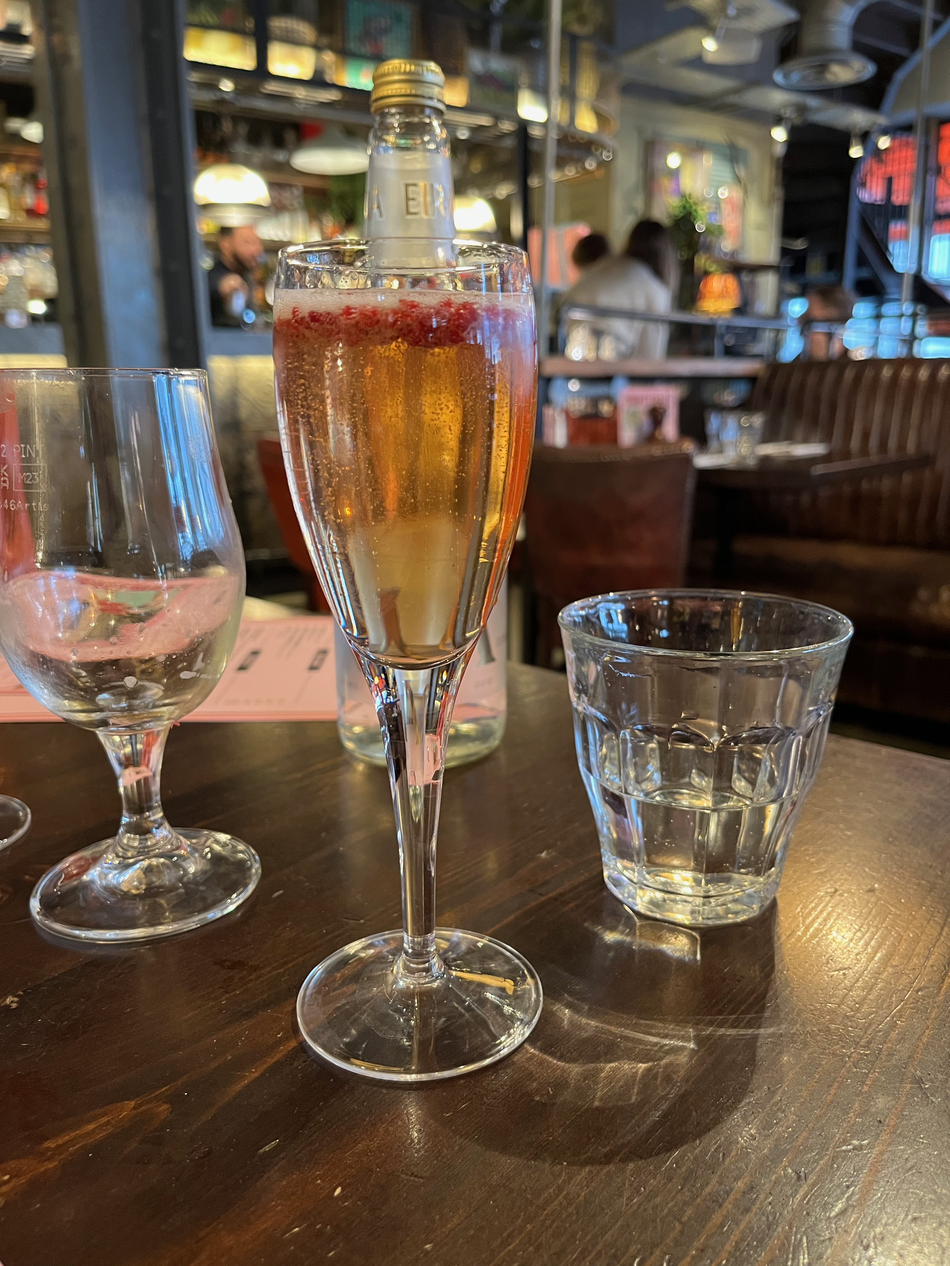 A cocktail at Bill's, with red berries floating on the top of it.