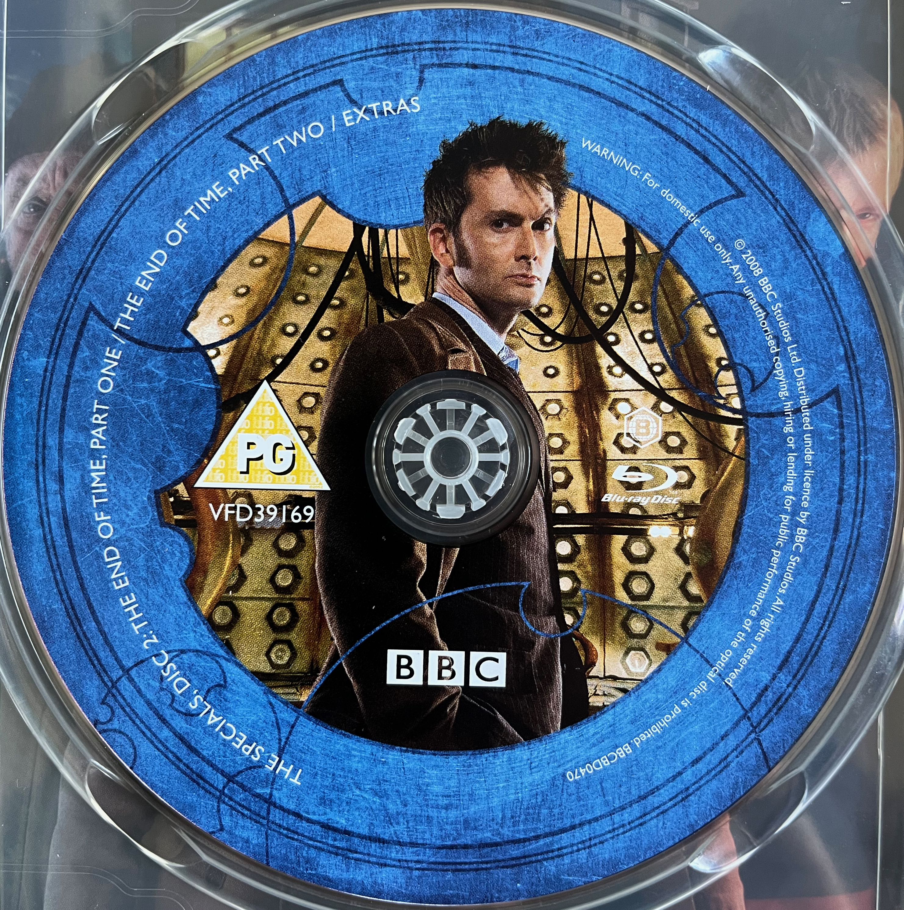 Disc 2 in the Doctor Who 2008 to 2010 Specials Blu-ray set. It features a photo of David Tennant as the Doctor in a pinstripe suit, standing inside the Tardis. A blue border around the edge of the disc contains the episode names and copyright information.