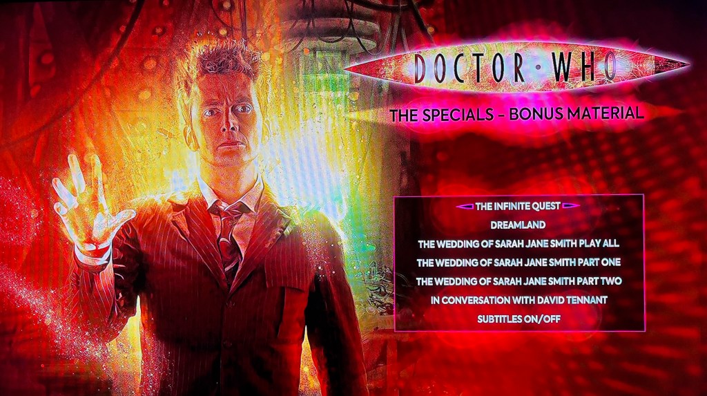 The menu for Disc 4 of the Doctor Who 2008 to 2010 specials Blu-ray steelbook, showing the various options below the Doctor Who logo on the right hand side, while to the left is an image of David Tennant's Doctor as he starts to regenerate.