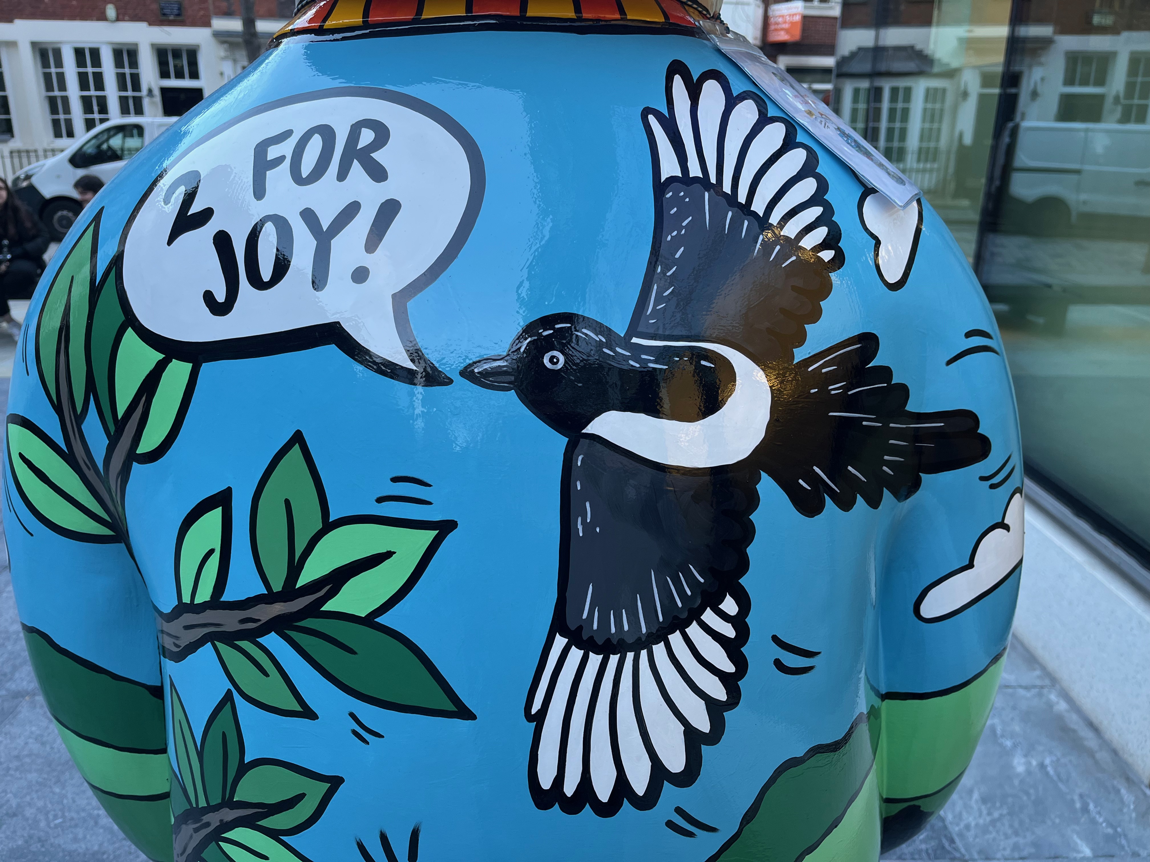 Close-up of a sculpture of The Snowman called Four Calling Birds, showing a black and white bird flying as it says 2 for joy.
