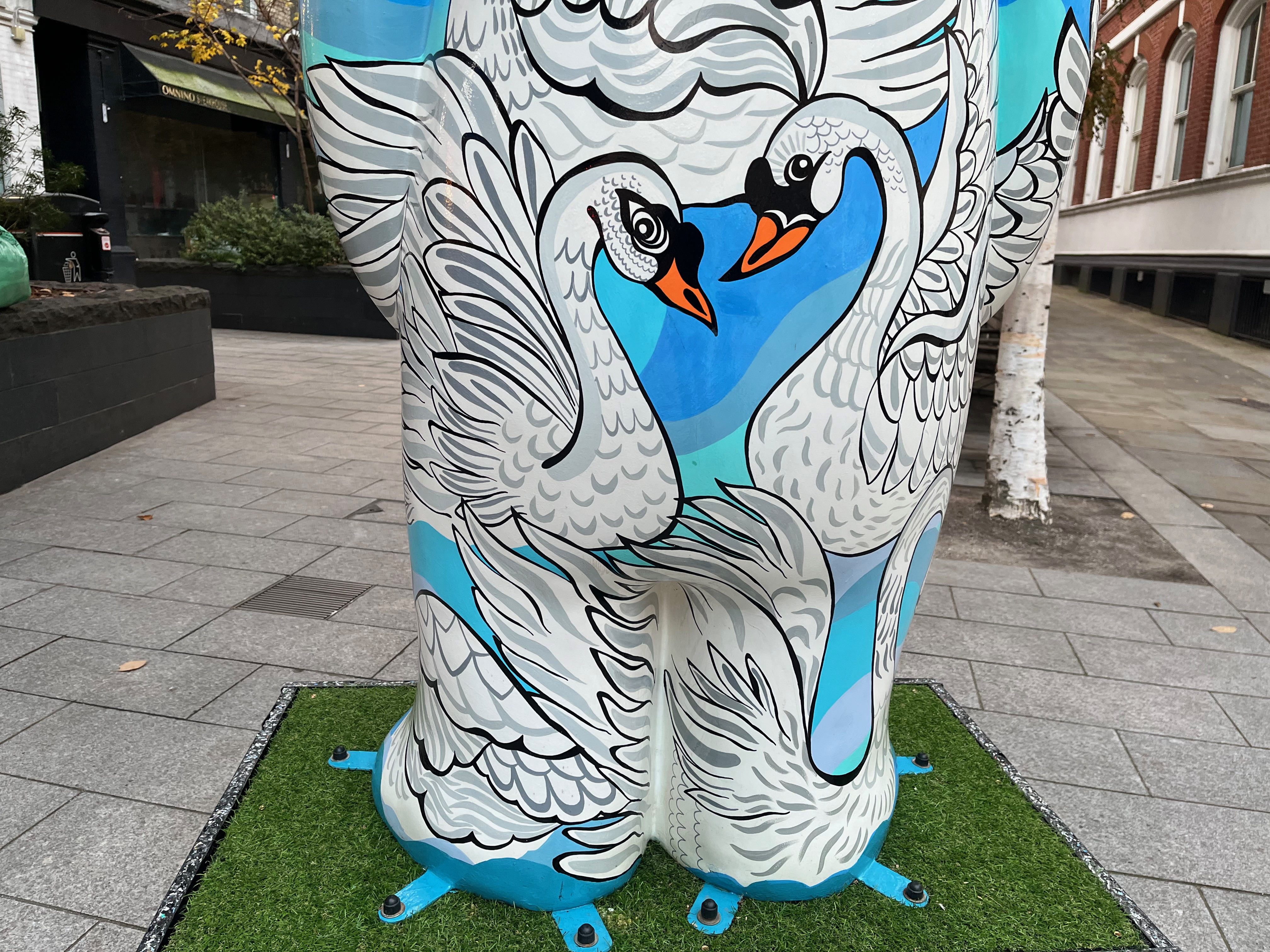 Close-up of 2 swans facing each other, their necks and heads forming a heart shape, on the back of the sculpture of The Snowman called Seven Swans a-Swimming.